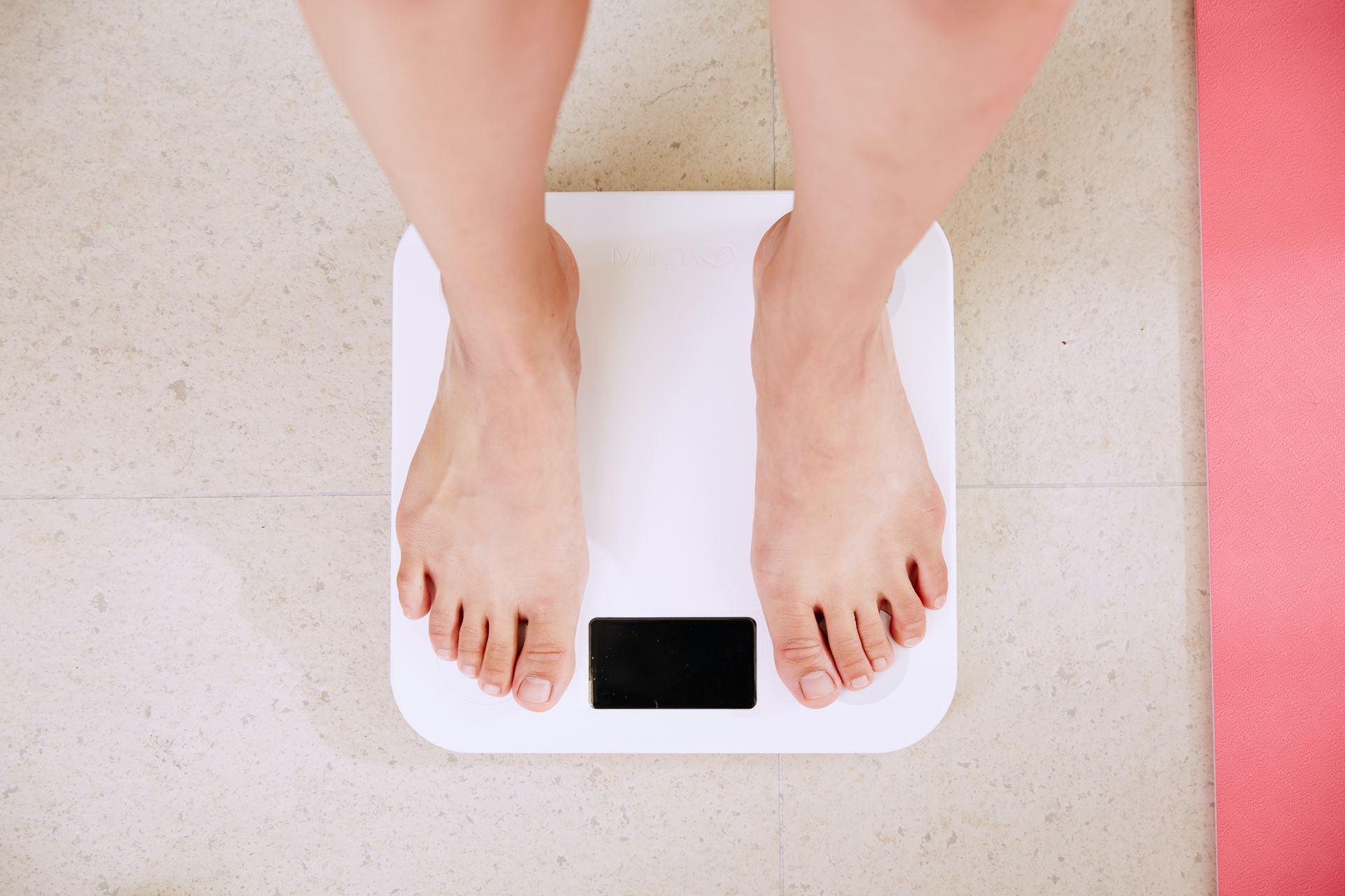 A person's feet standing on weighing scales