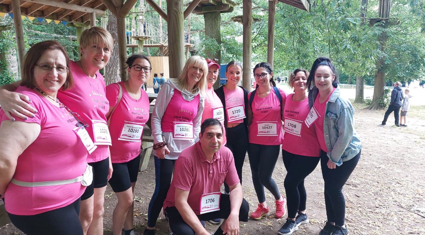 Our staff together at the race for life. Dr Dullo is crouched down in front of the rest of the team. They are all wearing pink t-shirts.