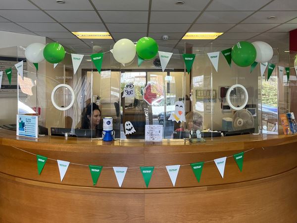 A photograph of our front desk with white and green bunting and balloons.